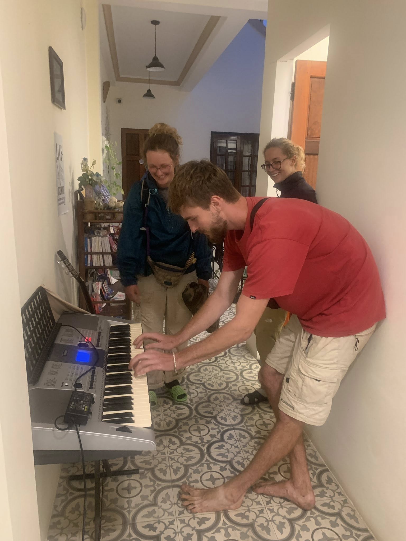 Du khách quốc tế chơi đàn phím và giao lưu âm nhạc tại không gian chung của Huế Eco Homestay.